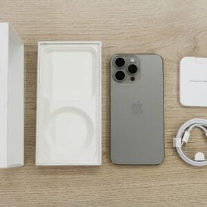 pexels-photo-18525574-18525574 Flat lay view of the newest Apple iPhone model, box, and charging accessories on a wooden table.