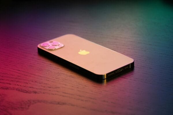 Close-up of a modern smartphone on a gradient-lit wooden surface, showcasing elegance.